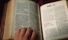 an open book being held by a person's hand in front of the pages