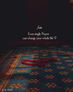 a red string laying on top of a rug with an arabic quote in the middle