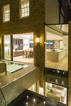 a modern house with an indoor pool and living room in the background at night time