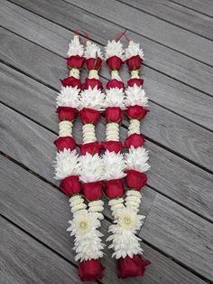 red and white flowers arranged in the shape of letters on a wooden decking area