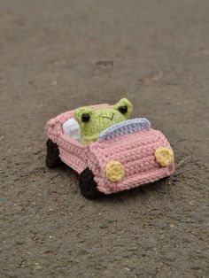 a small crocheted toy car sitting on the ground