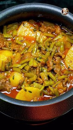 a pot filled with stew sitting on top of a stove