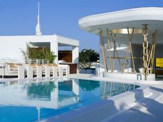 an outdoor swimming pool next to a white building