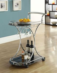 a bar cart with two wine glasses and bottles on the bottom shelf in a living room