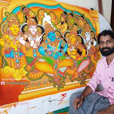 a man sitting in front of a painting on the wall