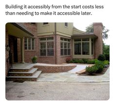 a brick house with steps leading up to the front door and landscaping area on either side