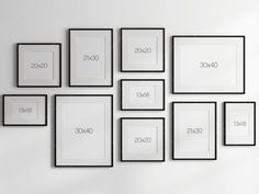 a white wall with black framed pictures on it and numbers in the frames above them