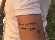 someone with a tattoo on their arm that says, always am angel never a god