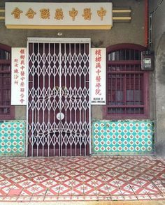 an entrance to a building with chinese writing on the wall and tile flooring in front