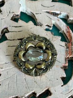 This brooch is a lovely antique one.  It is in great codnition for its age.  This brooch has a clear quartz crystal stone, with gorgeous ornate detailing all the way round it.  This brooch has a lovely size, with a diameter of approximately 3cm.  It is lovely and light weight as well.  If you love this and feel the price is a little out of reach, please pop me a message and we can sort something out. Vintage Gemstone Brooches For Formal Occasions, Vintage Brooch With Antique Finish, Vintage Bronze Brass Brooches, Vintage Brass Wedding Brooches, Bronze Victorian Brooches For Gifts, Victorian Bronze Brooches For Gift, Antique Bronze Brooches For Gift, Handmade Vintage Brooch For Anniversary, Handmade Vintage Brooches For Anniversary