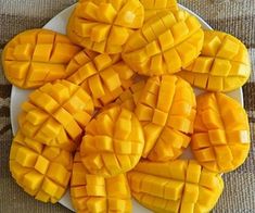 a white plate topped with sliced mangos on top of a table