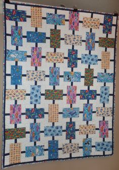 a blue and white quilt hanging on the wall