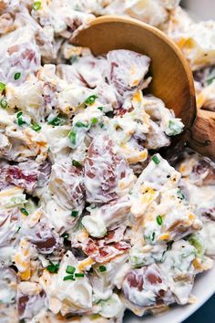 a bowl filled with potato salad and a wooden spoon on top of the dish, ready to be eaten