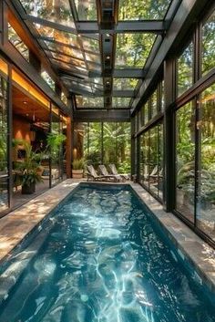 an indoor swimming pool in the middle of a house with glass walls and floor to ceiling windows