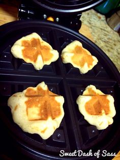 four waffles with peanut butter on them sitting on a black pancake maker