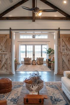 an open living room with wooden doors and furniture