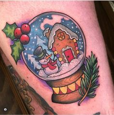 a snow globe with a christmas scene in it on the thigh, and holly wreaths