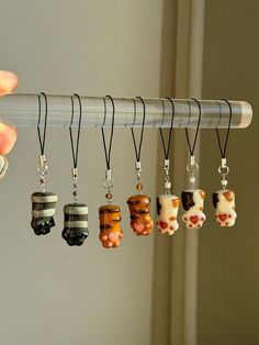 a person holding a rack with six different necklaces hanging from it