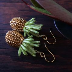 Adorable beaded pineapple dangle earrings, made with 24-karat gold plated beads and ear wires. Pineapples measure 30mm each. Total length of earrings: 50mm (about 2 inches.) © 2006-2021 Heart in Hawaii other pineapple designs available; sold separately Professionally handmade in the US; heirloom quality beadwork Truly unique; exclusive design; direct from the artist Gift wrapping and standard US shipping included Gold Drop Earrings With Fruit Design, Gold Fruit Design Drop Earrings, Pineapple Design, Artist Gifts, Ear Wires, Exclusive Designs, Bead Work, Pineapple, Hawaii