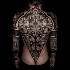 the back of a man's body with tattoos and geometric designs on his chest