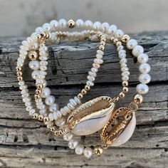 "Handmade stretch bracelet featuring pearls and a cowrie shell charm. So cute for resort / summer and stacks well with other bracelets! There are two sizes available: mini and standard. \"Mini\" consists of 3MM 14K gold beads and 3MM mini oval freshwater pearls. \"Standard\" consists of 4MM 14K gold beads and 4MM freshwater pearls.  Each bracelet is handmade to order and available in different sizes, though please note designs may vary slightly from listing photos depending on size. To find your Cowrie Shell Bracelet, Cowrie Shell Jewelry, Wax Cord Bracelet, Seashell Bracelet, Pearl Bracelet Wedding, Summer Beach Jewelry, Beachy Jewelry, White Pearl Bracelet, Gold Anklet