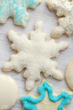 several decorated cookies on a table with blue and white frosting, including one snowflake