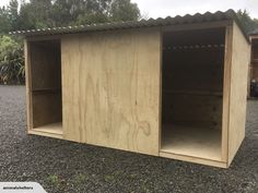 a wooden storage shed sitting on top of gravel