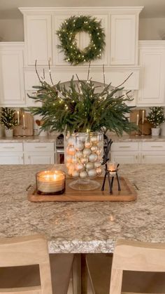 a kitchen counter with candles and wreaths on it