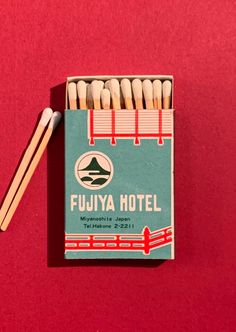 a matchbox with matches on top of it next to a pair of chopsticks