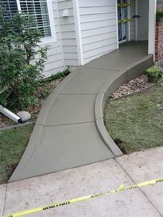 a house with a sidewalk that has been laid in front of it and tape is on the ground