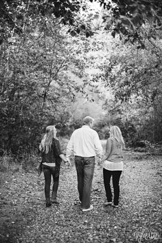 three people walking down a path holding hands