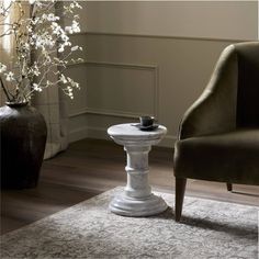 a living room with a chair, table and flowers in vases on the floor