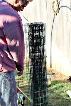 a man standing next to a bird cage