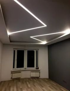 an empty room with hard wood floors and white lighting on the ceiling is lit by recessed lights