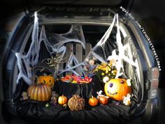 halloween decorations in the back of a car with spider webs and pumpkins on it