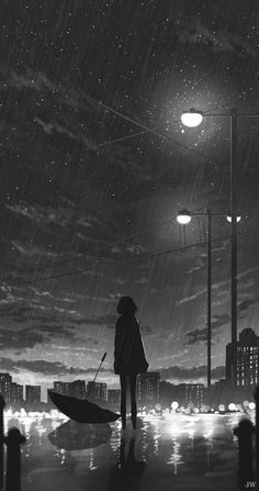 a person standing in the rain with an umbrella under a street light at night time