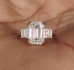 Emerald Cut Moissanite Engagemen Ring/Vintage Bridal Promise Ring/Art Deco Rose Gold Cluster Baguette Diamond Wedding Ring/Anniversary Gift  𝐂𝐞𝐧𝐭𝐞𝐫 𝐒𝐭𝐨𝐧𝐞 𝐃𝐞𝐭𝐚𝐢𝐥𝐬 ↣ Stone : Moissanite & Simulated (Select a Material) ↣ Shape : Emerald Cut ↣ Size : 10x7 MM ↣ Weight : 3.25 Carat (Approx) ↣ Color : DEF ↣ Clarity : VVS ↣ Luster : excellent ↣ Make : high quality ↣MOHs scale : 9.25 ↣Moissanite Refractive index : 2.65 ✥ 𝐒𝐢𝐝𝐞 𝐒𝐭𝐨𝐧𝐞 𝐃𝐞𝐭𝐚𝐢𝐥𝐬 ↣ Stone : Moissanite & Simulated Timeless Emerald Cut Wedding Jewelry, Rectangular Wedding Ring With Prong Setting, Rectangular Wedding Ring With Center Stone, Gia Certified Emerald Cut Wedding Ring, Wedding Diamond Ring With Rectangular Center Stone, Art Deco Emerald Cut Diamond Wedding Ring, Rectangular Diamond Ring With Center Stone For Wedding, Rectangular Brilliant Cut Wedding Rings, Art Deco Radiant Cut Wedding Ring