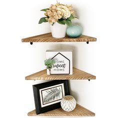 three wooden shelves with plants and pictures on them, one has a framed photo next to it