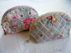 two coin purses sitting on top of a bed