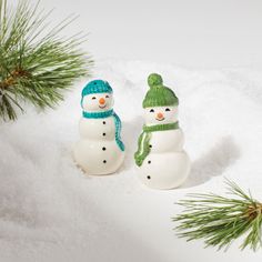 two small snowmen are sitting in the snow