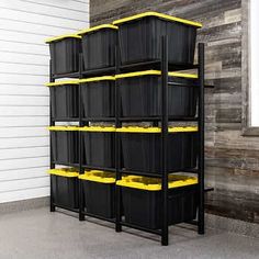 several black bins with red lids are stacked on a shelf