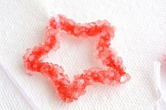 two pieces of red glass sitting on top of a white towel next to a toothbrush