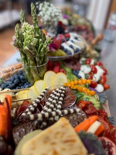 a table topped with lots of different types of vegetables and fruit on top of each other