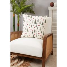 a chair with a pillow on top of it next to a potted palm tree