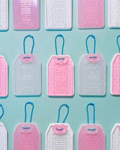 pink and white tags with blue string attached to them on a light blue tablecloth