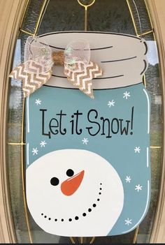 a door hanger with a snowman in a mason jar on it's side