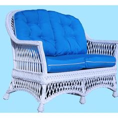 a white wicker chair with blue cushions on a light blue background in the shape of a reclining couch