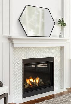 a white fireplace with a mirror above it