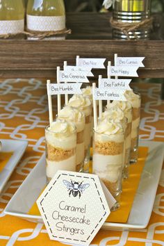 mini cheesecakes in small glass jars on a yellow tablecloth with white tags