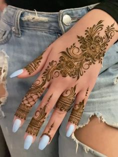 a woman's hand with henna tattoos on her left arm and the bottom half of